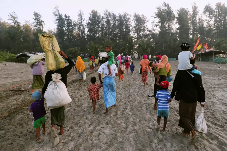 A group of Rohingya refugees, who fled last night from Myanmar by boat, walk towards a makeshift camp in Cox's Bazar, Bangladesh