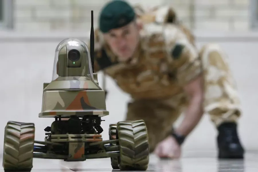 A Royal Marine poses for photographers with the Unmanned Vehicle Robot, Testudo, at the launch of the Defense Technology Plan in London on February 26, 2009. 