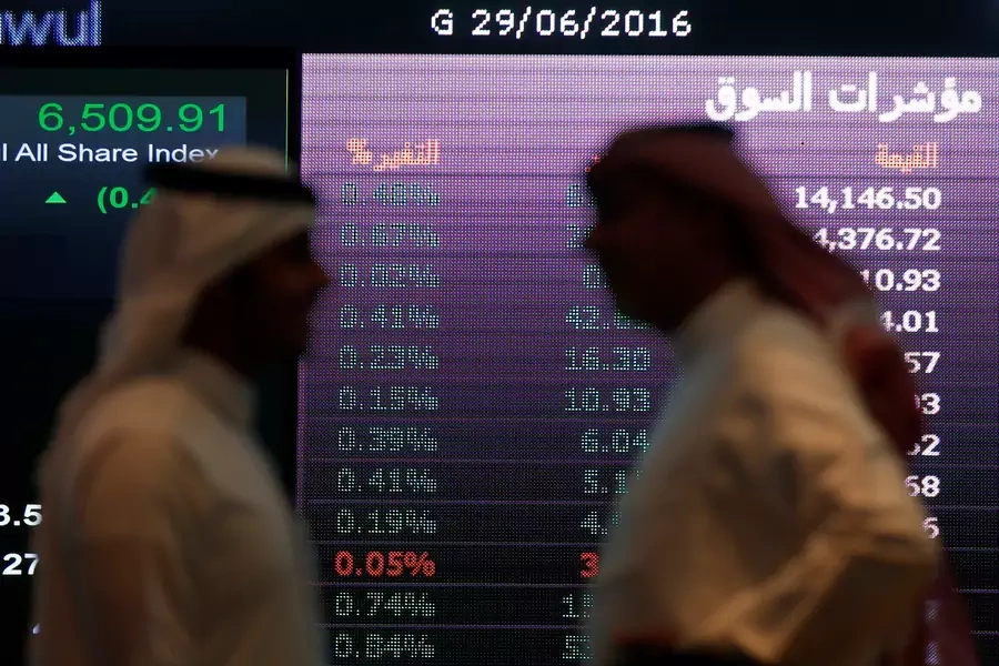 Investors talk with each other as they monitor a screen displaying stock information at the Saudi Stock Exchange (Tadawul) in Riyadh, Saudi Arabia June 29, 2016.