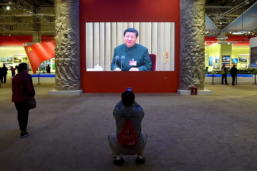 A man takes a picture of a screen showing Chinese President Xi Jinping in October 2017.