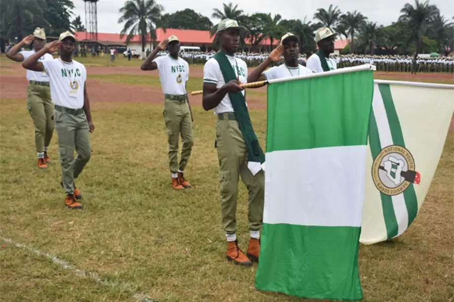 National Youth Service Corps (NYSC) members display the Nigerian and NYSC flags during a parade in Nigeria.