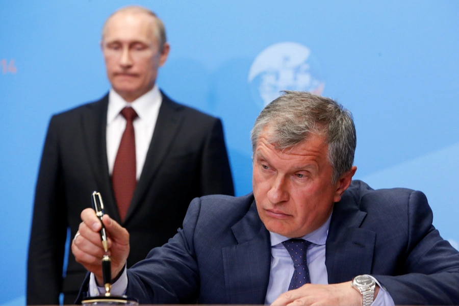 Russia's President Vladimir Putin (back) and Rosneft CEO Igor Sechin attend a signing ceremony at the St. Petersburg International Economic Forum 2014 (SPIEF 2014) in St. Petersburg, Russia, May 24, 2014. 