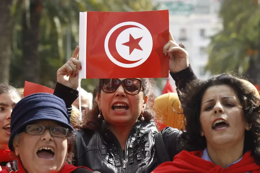 A Tunisian woman holds up a Tunisian flag during a march to celebrate International Women's Day in Tunis March 8, 2014. 