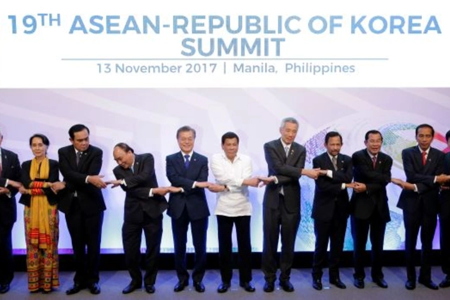 Summit participants join hands during a family photo before the 19th ASEAN Republic of Korea Summit in Manila, Philippines November 13, 2017.