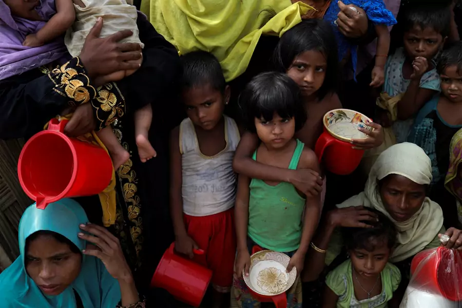 Rohingya women and children wait to get distributed meals at Moynarghona refugee settlement near Cox's Bazar, Bangladesh, November 24, 2017.