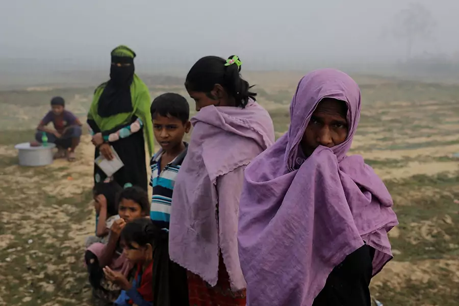Rohingya refugees wait for rice delivery during a foggy morning at the Nayapara refugee camp near Cox's Bazar, Bangladesh on December 25, 2017.