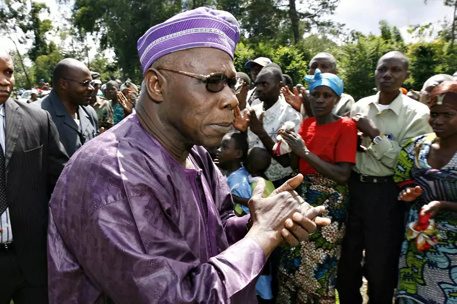 Former Nigerian President Olusegun Obasanjo greets people as he arrives to meet rebels in the village of Jnomba in eastern Congo, November 16, 2008.