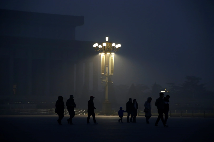 People arrive at Tiananmen Square for a flag-raising ceremony during smog after a red alert was issued for heavy air pollution in Beijing, China, December 20, 2016.