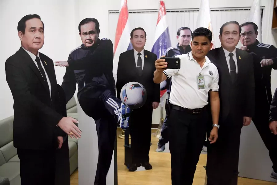 A journalist selfies with cardboard cut-outs of Thailand's Prime Minister Prayuth Chan-ocha at Government House in Bangkok, Thailand, on January 9, 2018.