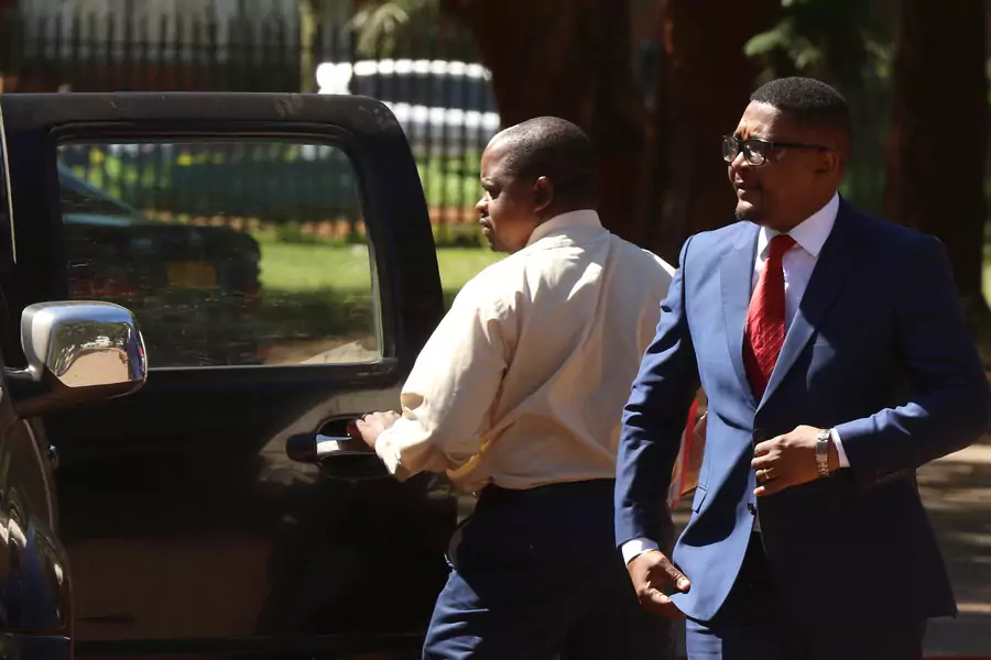 Former Minister of Foreign Affairs Walter Mzembi is escorted by a detective during his appearance at the Harare Magistrates Court in Harare, Zimbabwe, January 6, 2018. 