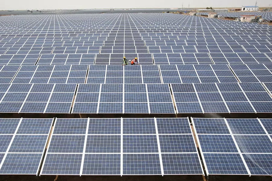 Workers install photovoltaic solar panels at the Gujarat solar park under construction in Charanka village, in Patan district of the western Indian state of Gujarat, India, April 14, 2012.