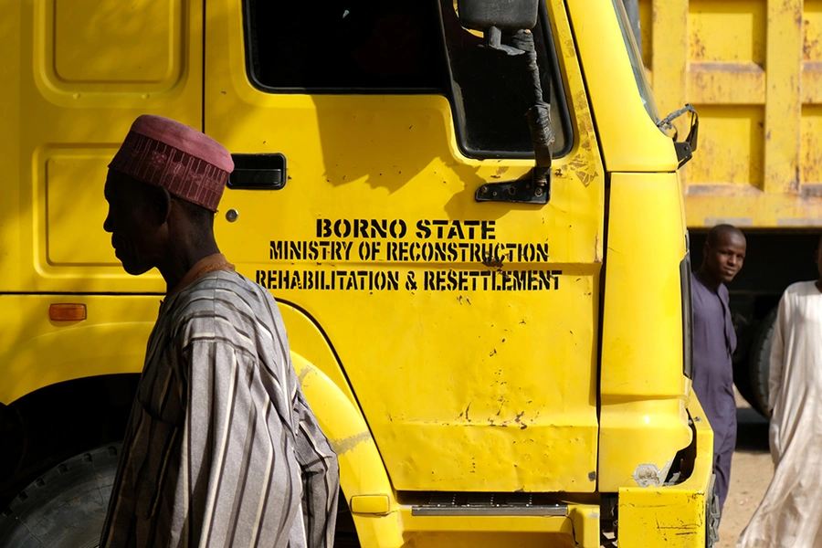 A man walks past a truck piled high with people, their belongings and construction materials in the Muna Garage Maiduguri, Nigeria February 16, 2017.