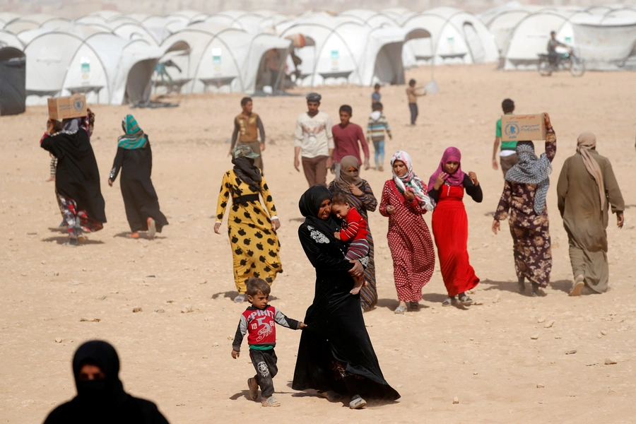 People displaced from fightings between the Syrian Democratic Forces and Islamic State militants carry boxes of food aid given by UN's World Food Programme at a refugee camp in Ain Issa, Syria October 10, 2017. 