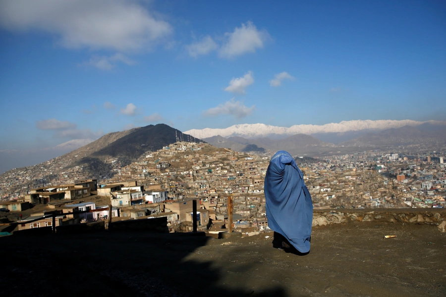 An Afghan woman walks on a hilltop overlooking Kabul, Afghanistan February 27, 2018. 