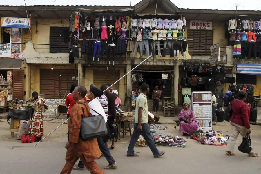 People walk past market stalls in Nigeria's commercial capital Lagos January 16, 2012.