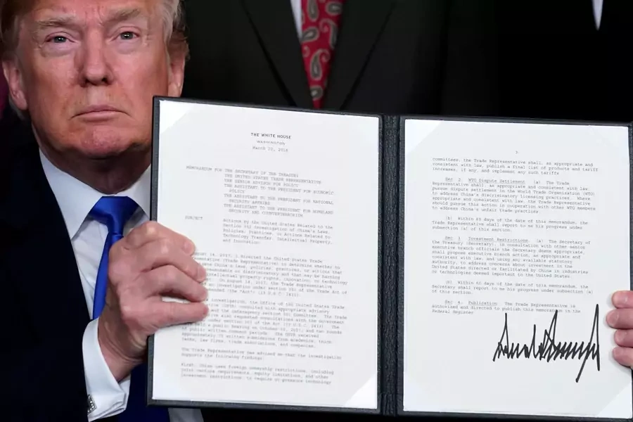 U.S. President Donald Trump holds a signed memorandum on intellectual property tariffs on high-tech goods from China, at the White House on March 22, 2018.