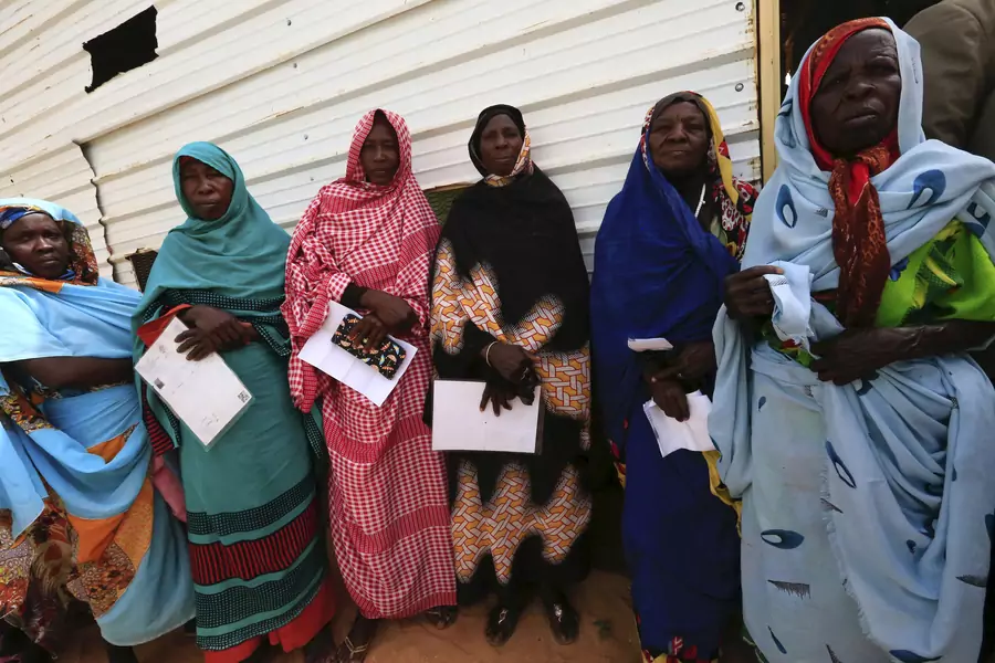Women carry identification papers during the registration for a Darfur referendum, at a registration centre at Abo-Shouk IDP camp at Al Fashir in North Darfur, February 17, 2016.