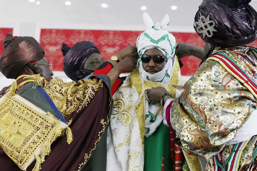 New Emir of Kano Muhamadu Sanusi II ( 2nd R) is dressed by the Kingmakers, a traditional role charged with officially dressing the king, during his coronation in Kano, Kano State, February 7, 2015. 