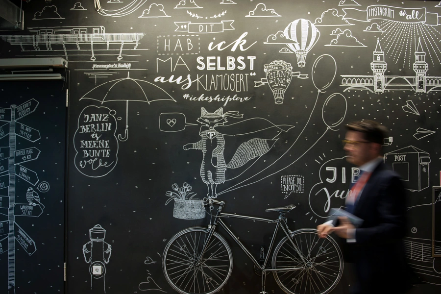 A man walks in front of a mural at the Facebook office in Berlin on August 29, 2016.