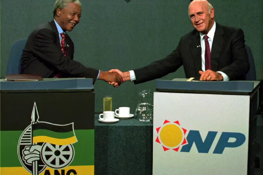 South African President F.W. de Klerk (R) shakes hands with African National Congress (ANC) President Nelson Mandela during a televised debate April 14, 1994.