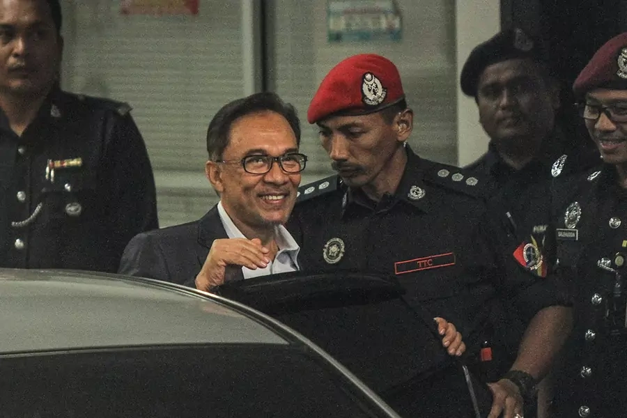 Malaysian opposition leader Anwar Ibrahim is escorted by prison officers near the court lock-up after his hearing in a sodomy case in Putrajaya, Malaysia, on October 12, 2016.