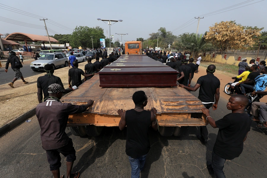 Men march along a truck carrying the coffins of people killed by herdsmen, in Makurdi, Nigeria, January 11, 2018.
