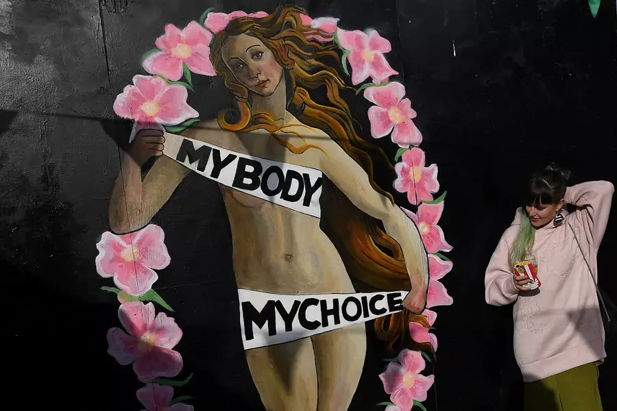 A woman stands beside a pro-choice mural ahead of a May 25 referendum on abortion law, in the centre of Dublin, Ireland on May 12, 2018