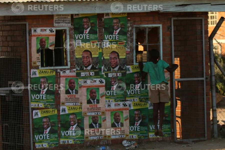 A boy plays next to election posters at White City Stadium where Zimbabwe's President Emmerson Mnangagwa escaped unhurt after an explosion rocked the stadium, in Bulawayo, Zimbabwe, June 23, 2018. 