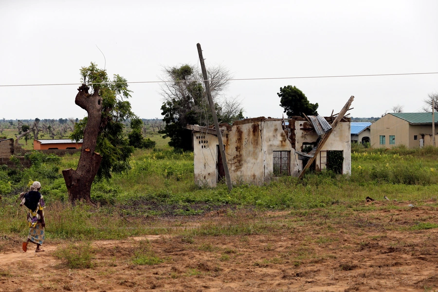 A woman walks toward a house damaged by Boko Haram militants, along the Konduga-Bama road in Bama, Borno, Nigeria, August 31, 2016.