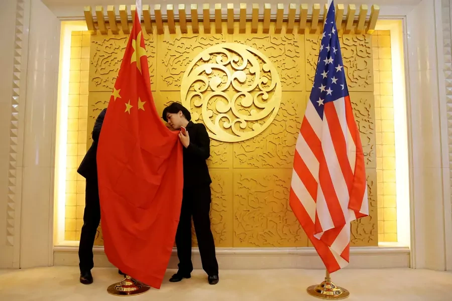 Staff members set up Chinese and U.S. flags for a meeting between Chinese Transport Minister Li Xiaopeng and U.S. Secretary of Transportation Elaine Chao at the Ministry of Transport of China in Beijing, China April 27, 2018