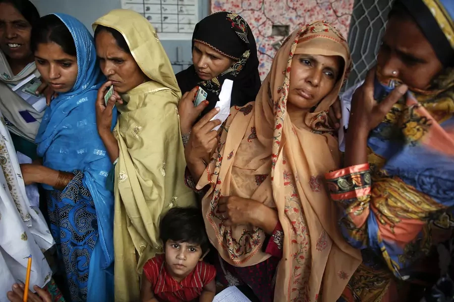 Women wait to vote at a polling station in a village near Lahore in 2013.