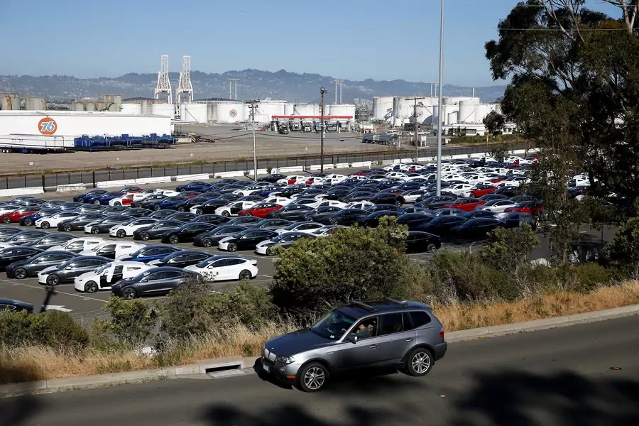 A motorist drives past a parking lot full of new Tesla electric vehicles in Richmond, California, U.S. June 22, 2018.