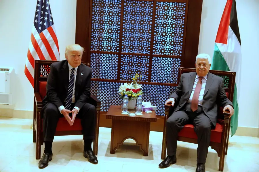 U.S. President Donald Trump (L) and Palestinian President Mahmoud Abbas wait for photographers to depart before beginning their meeting at the Presidential Palace in the West Bank city of Bethlehem 