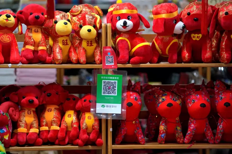 QR codes of Alipay (top) and Wechat Pay are seen next to toys displayed for sale at a shop ahead of the Lunar Year of the Dog in Beijing, China on February 8, 2018. 