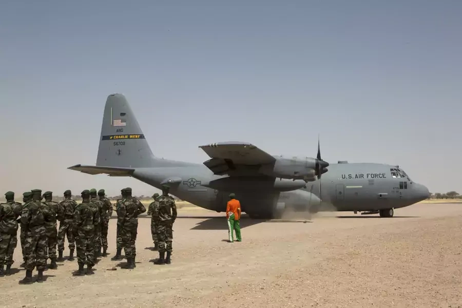 A C-130 U.S. Air Force plane lands as Nigerien soldiers stand in formation during the Flintlock military exercise in Diffa, March 8, 2014.