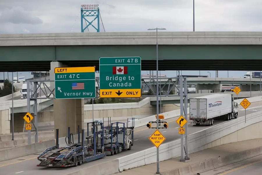 Semi trucks headed for Windsor, Ontario, exit onto the lane towards the Ambassador bridge in Detroit, Michigan on April 26, 2017.