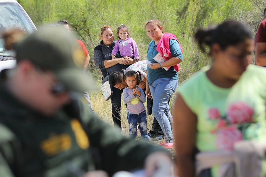 Central American asylum seekers wait as U.S. Border Patrol agents take them into custody near McAllen, Texas. The families were then sent to a U.S. Customs and Border Protection (CBP) processing center for possible separation.