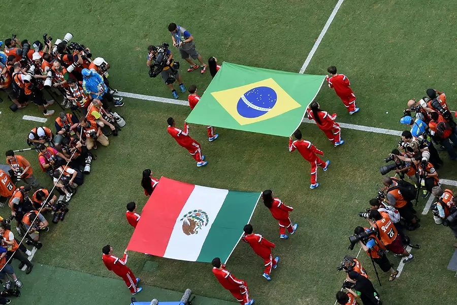  Flag bearers carry the Mexican and Brazilian flags out onto the pitch prior to the 2014 FIFA World Cup Brazil Group A match between Brazil and Mexico at Castelao on June 17, 2014 in Fortaleza, Brazil.