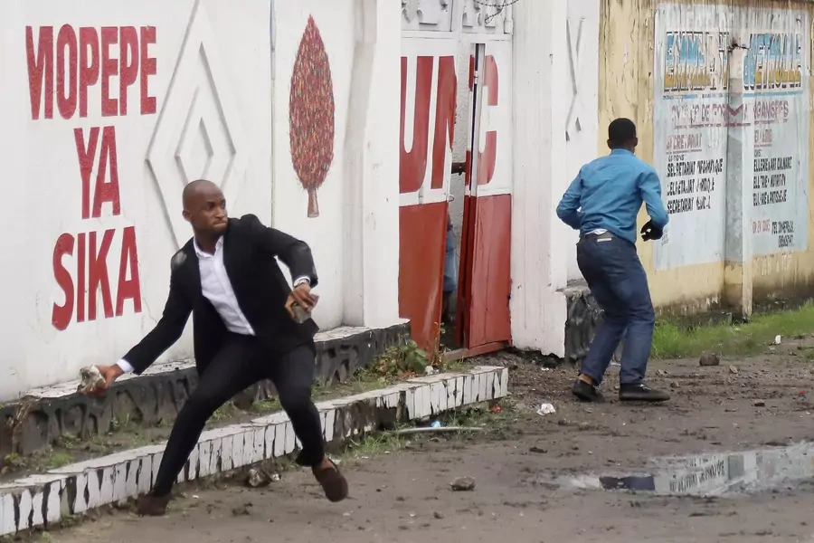 A man hurls stones during clashes between supporters of political rivals in Kinshasa, Democratic Republic of Congo, on November 12, 2018.