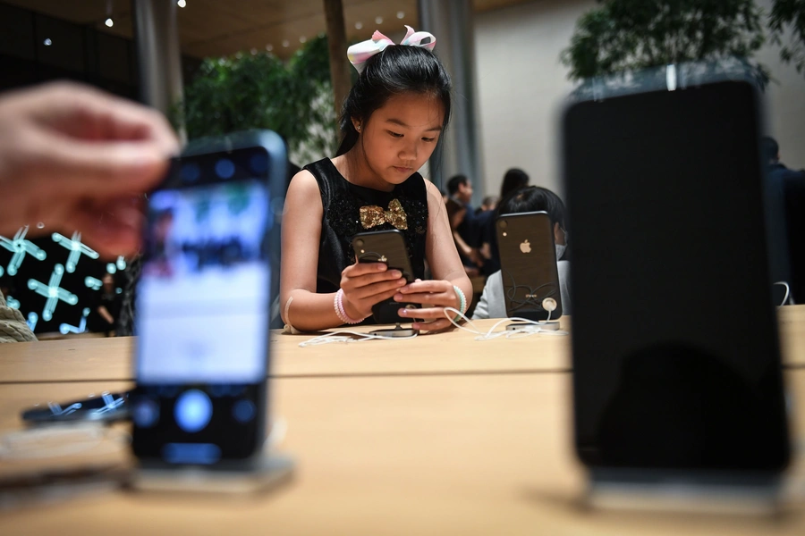 Young girl checks out an iPhone in November 2018.