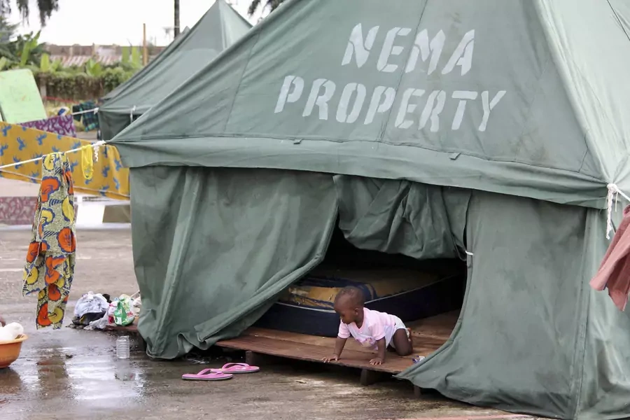 A child is seen crawling in a tent belonging to the National Emergency Management Agency (NEMA) at a relief centre for flood victims in Igbogene community Bayelsa state October 12, 2012.