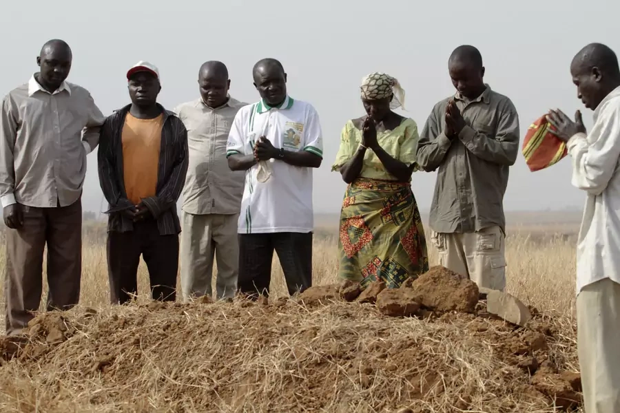 A family gathers around the grave where three family members shot dead by armed Fulani herdsmen are buried together, in Jos in Nigeria's Plateau state, on December 28, 2011.