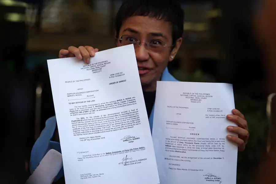 Maria Ressa, an executive of online news platform Rappler, shows her arrest warrant and release order after posting bail for tax evasion charges at Regional Trial Court Branch 265 in Pasig City, Metro Manila, in Philippines, on December 3, 2018.