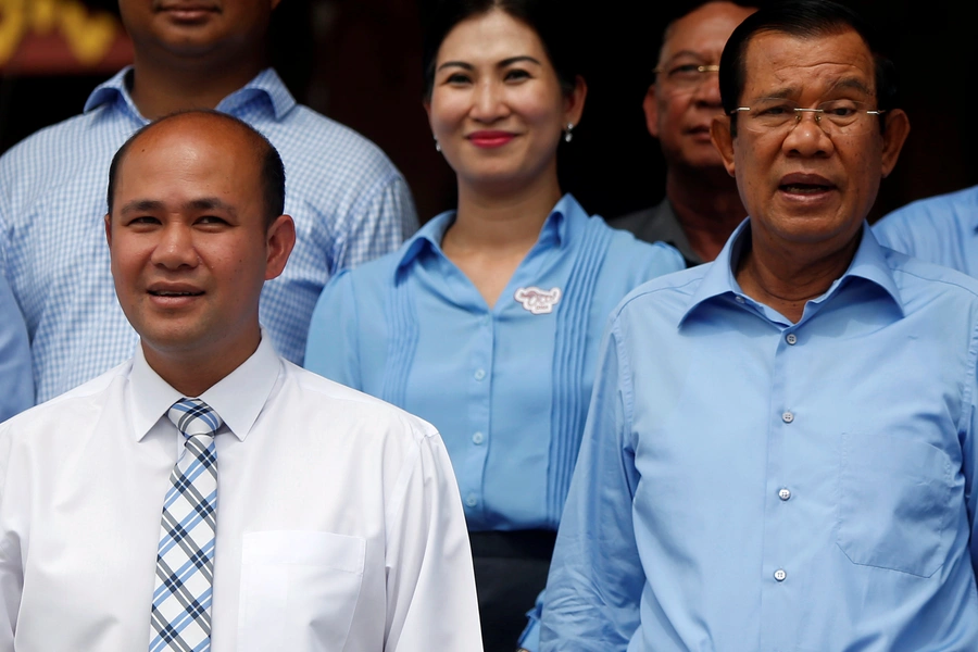 Cambodia's Prime Minister Hun Sen (R) and his son Hun Many (L), attend a campaign to break the world record for longest cotton scarf weaved, by reaching a length of 1000 meters, in Phnom Penh, Cambodia, June 7, 2018. 