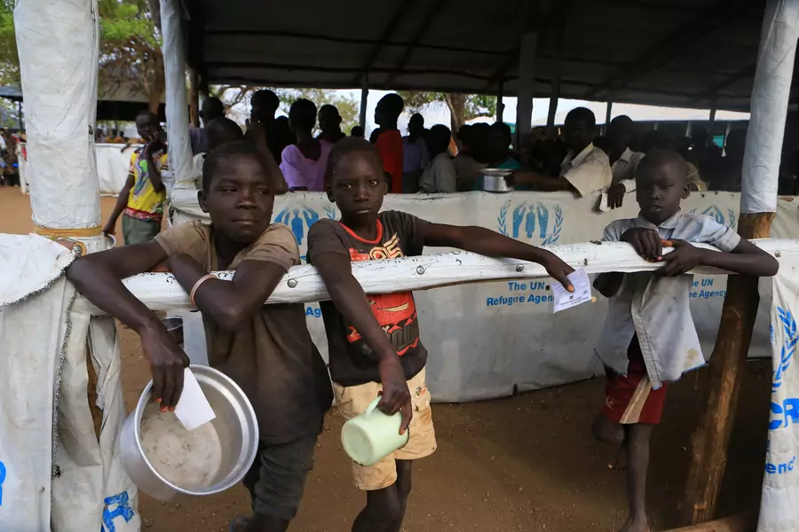 South Sudanese refugee children displaced by fighting hold utensils as they wait for a warm meal at Imvepi settlement in Arua district, northern Uganda, on April 4, 2017. 