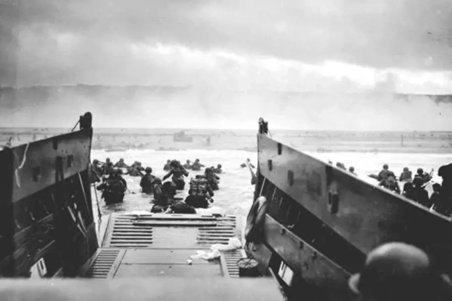 U.S. troops wade ashore from a Coast Guard landing craft at Omaha Beach during the Normandy D-Day landings on June 6, 1944. 