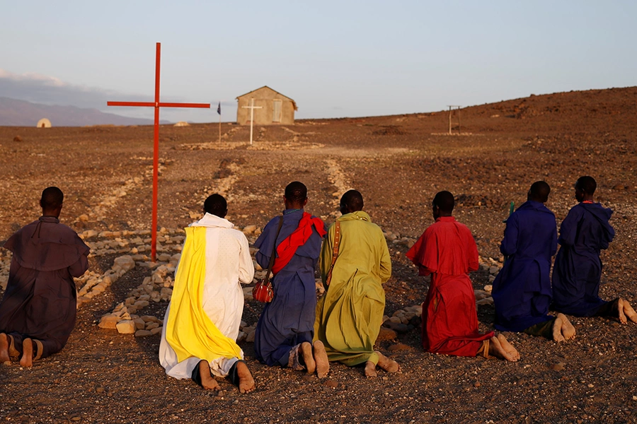 Turkana men pray outside a Legio Maria African Mission Church in Loiyangalani, Kenya, on August 5, 2017.