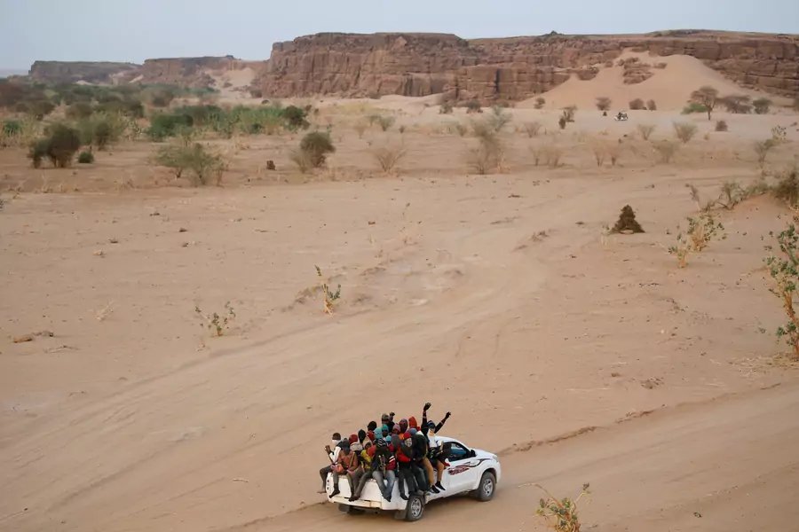 Migrants crossing the Sahara desert into Libya ride on the back of a pickup truck outside Agadez, Niger, on May 9, 2016. 