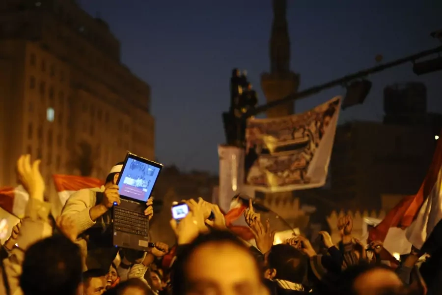An opposition supporter holds up a laptop showing images of celebrations in Cairo's Tahrir Square, after Egypt's President Hosni Mubarak resigned February 11, 2011
