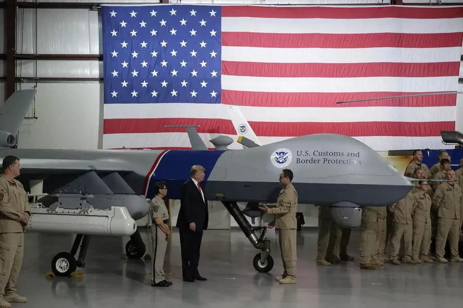 U.S. President Donald Trump puts his hand on a drone aircraft used to patrol the border at U.S. Customs and Border Patrol facility in Yuma, Arizona, U.S., August 22, 2017.
